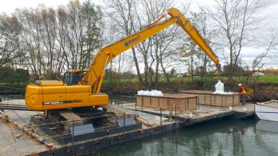 A l’aide de pelles sur ponton :  manutention des fûts de produits pétroliers en sacs étanches, transport fluvial jusqu’à la zone de reprise